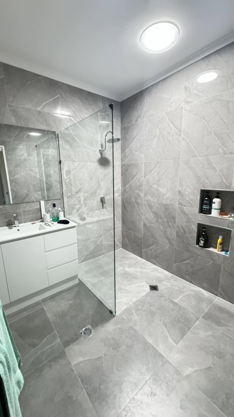B&Y Mackay bathroom renovation with grey stone-look tiling and frameless walk-in shower